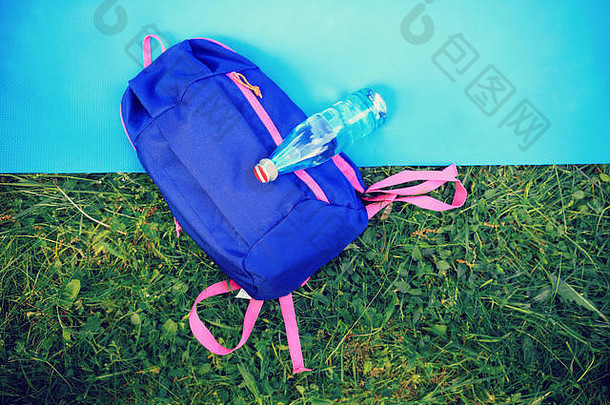 夏天运动背景瓶水背包健身房席绿色草背景