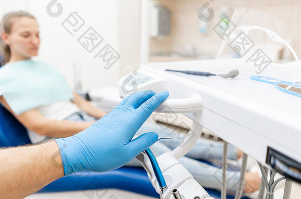 特写镜头手牙医手套持有牙科高速度涡轮病人蓝色的椅子背景办公室牙医进行