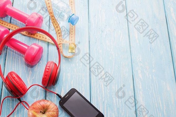 新鲜的水果哑铃木工作台面复制空间饮食健康的食物概念耳机电话音乐体育运动