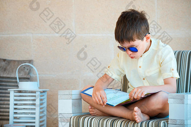 年轻的男孩阅读书户外阳台
