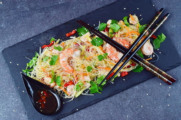 面条虾蔬菜黑色的石头板传统的东方酱汁灰色摘要背景健康的食物概念