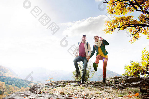 美丽的夫妇阳光明媚的秋天自然跳岩石