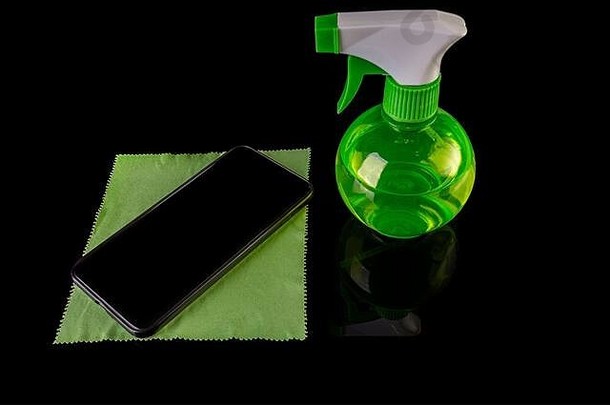消毒喷雾瓶黑色的智能手机孤立的黑色的<strong>背景</strong>防止家庭清洁冠状病毒