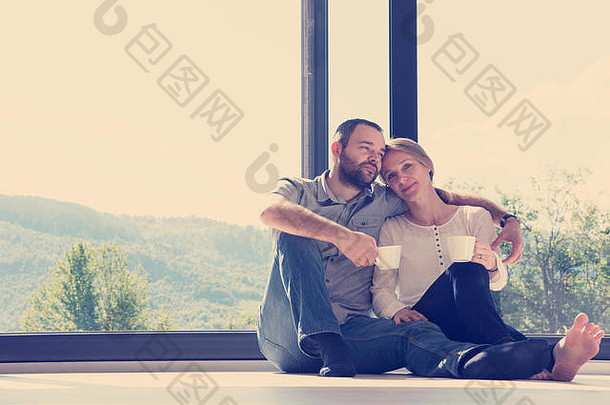 快乐浪漫的夫妇享受早....咖啡地板上窗口奢侈品首页