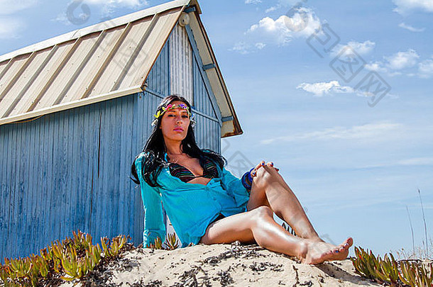 视图美丽的女人比基尼海滩沐浴阳光明媚的射线夏天蓝色的木房子