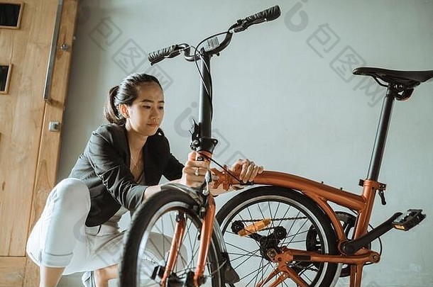 亚洲女人准备折叠自行车首页工作