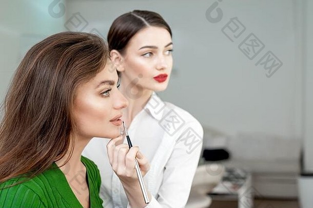 化妆艺术家适用于口红美丽的女人脸使过程