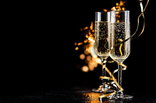 香槟眼镜金丝带闪光黑色的背景一年庆祝活动