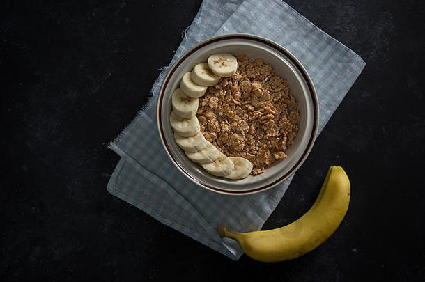 有机健康的燕麦片粥新鲜的香蕉白色瓷碗餐巾下面碗