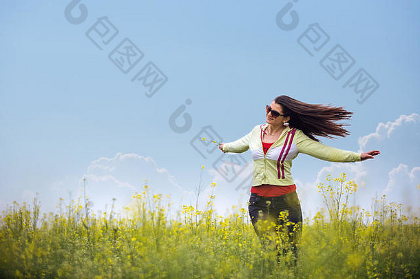 年轻的美丽的女孩享受阳光明媚的一天小麦场