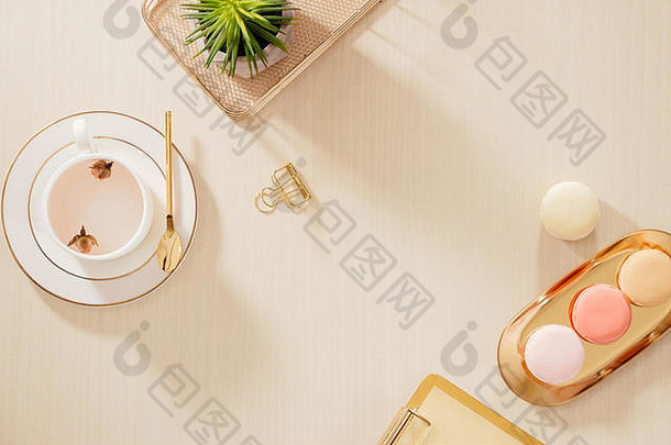 现代黄金程式化的首页办公室桌子上文件夹蛋白杏仁饼咖啡杯子米色背景平躺前视图生活方式概念