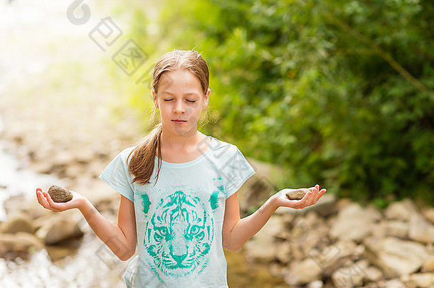 年轻的瑜伽女孩冥想日出山流女模型冥想宁静和谐石头手