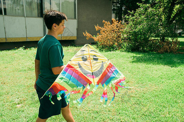 年轻的少年玩风筝阳光明媚的一天学校院子里