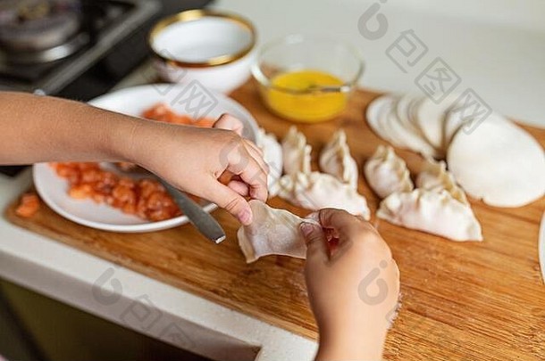 孩子手烹饪饺子生大马哈鱼厨房保持首页冠状病毒科维德流感大流行健康的生活方式概念