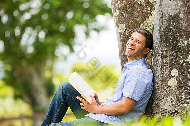 男人。阅读书公园坐着树放松在户外阅读