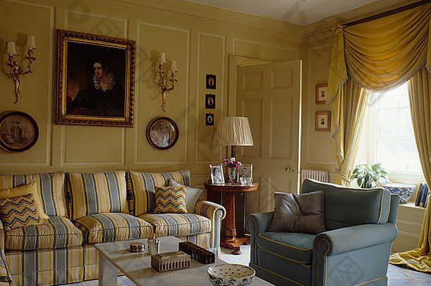 黄色的蓝色的条纹沙发蓝色的扶手椅奶油有饰板的生活房间摇动黄色的窗帘