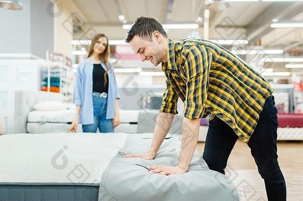 夫妇检查床垫家具商店展厅