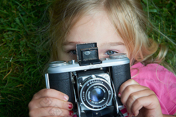 肖像女孩采取图片古董复古的电影相机说谎草背景