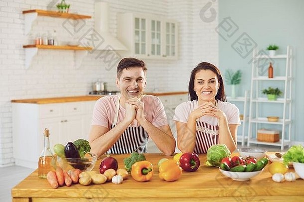 快乐中间夫妇微笑表格新鲜的蔬菜使沙拉厨房
