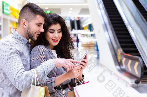 年轻的夫妇手机使在线订单购物中心
