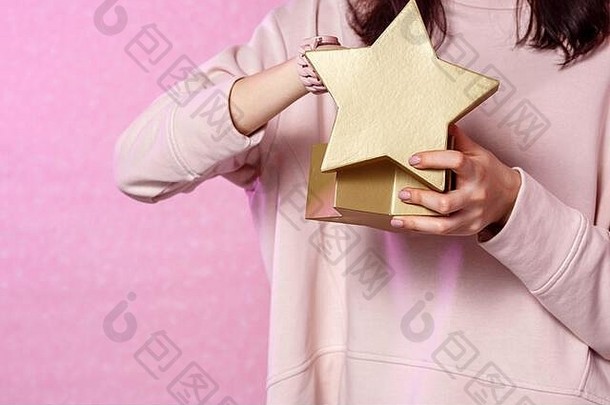 礼物盒子形状黄金明星手年轻的亚洲女孩粉红色的孤立的背景