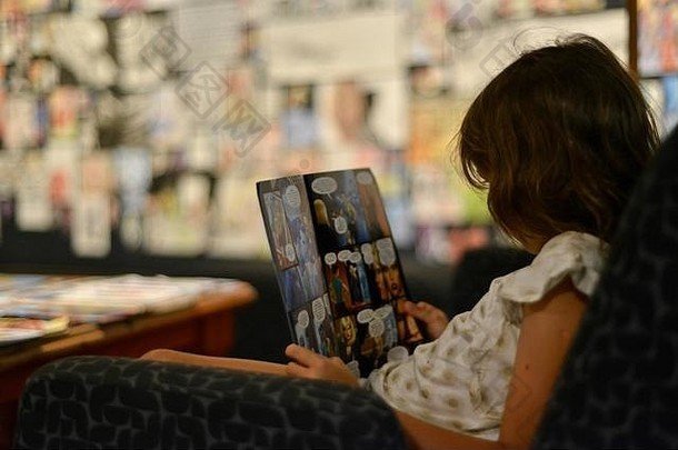 年轻的女孩读取漫画书河道汤斯维尔昆士兰澳大利亚