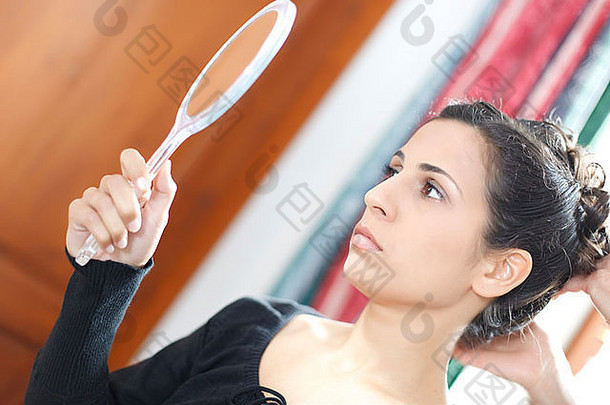 年轻的女人暂时回顾样式镜子