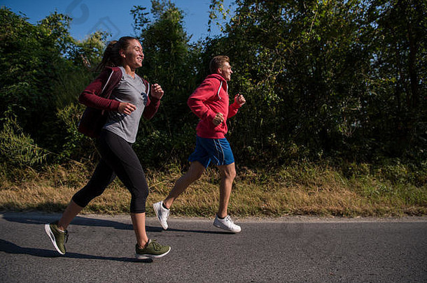 年轻的夫妇享受健康的生活方式慢跑国家路锻炼健身概念