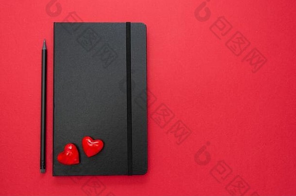 黑色的笔记本红色的背景心表格前爱情人节一天消息