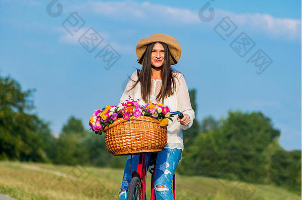 年轻的女孩游乐设施自行车篮子完整的花