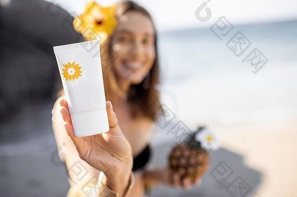 美丽的微笑女孩显示管防晒霜乳液休息海滩图像集中管太阳保护概念皮肤