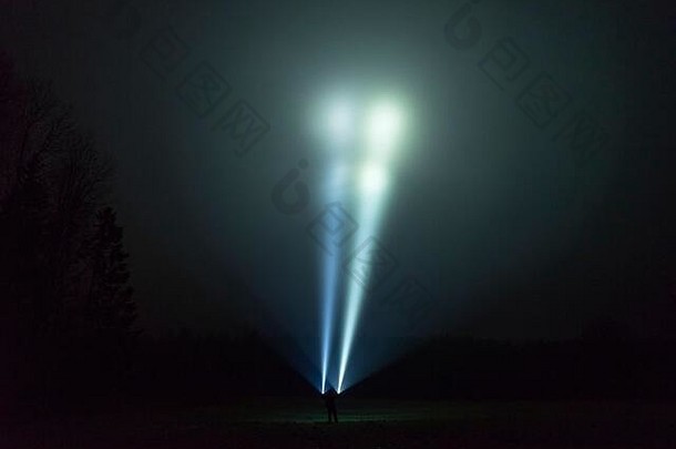 男人。站户外多雨的多雾的晚上闪亮的手电筒神秘的摘要照片瑞典自然景观