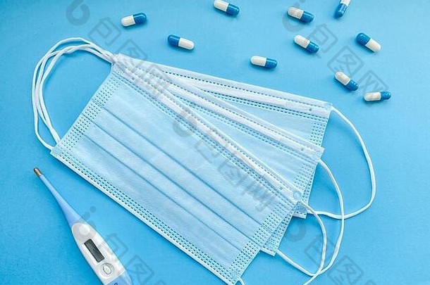 医疗面具胶囊电子温度计孤立的蓝色的背景概念医学健康