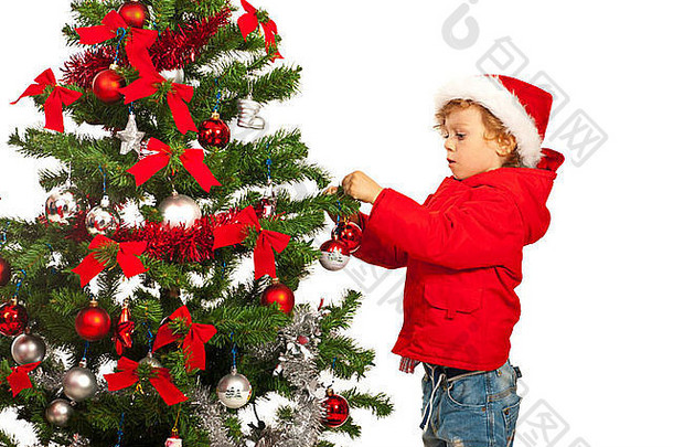 男孩把色彩斑斓的球圣诞节树白色背景