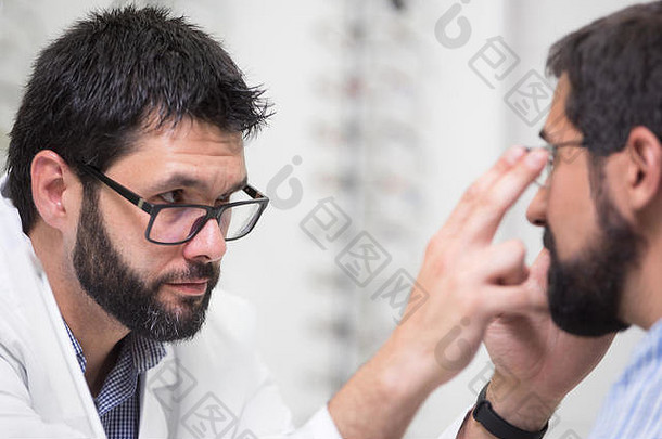 眼镜商提供眼镜客户测试眼睛医生显示病人镜头演出商店专业验光师白色外套客户端