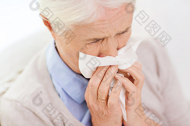 生病的高级女人吹鼻子纸餐巾