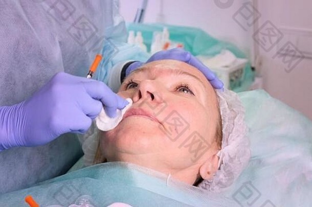 美容师医生准备女人的脸化妆品注射注射透明质酸酸女人美沙龙塑料手术诊所