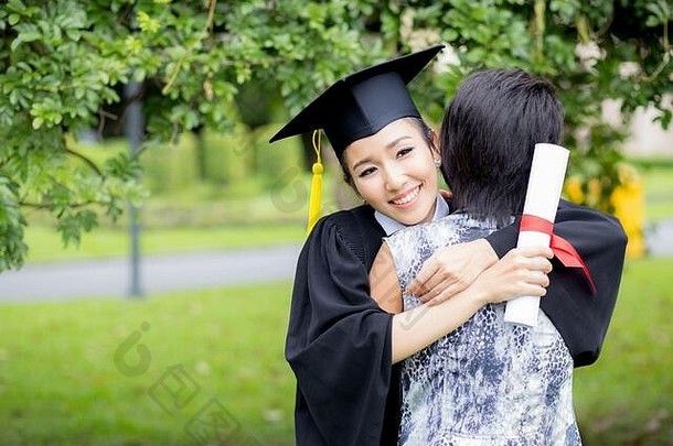 年轻的女研究生拥抱朋友毕业仪式