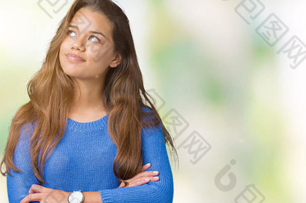 年轻的美丽的浅黑肤色的女人女人穿蓝色的毛衣孤立的背景微笑一边盯着思考
