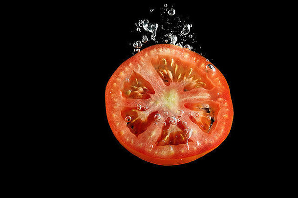 番茄片下降水黑色的背景