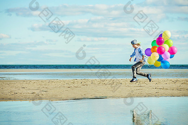 快乐男孩戏剧彩色的气球海滩