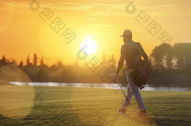英俊的中间东部高尔夫球手携带袋走洞高尔夫球美丽的日落背景
