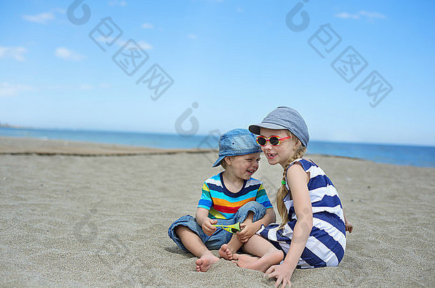 小孩子们坐着海滩