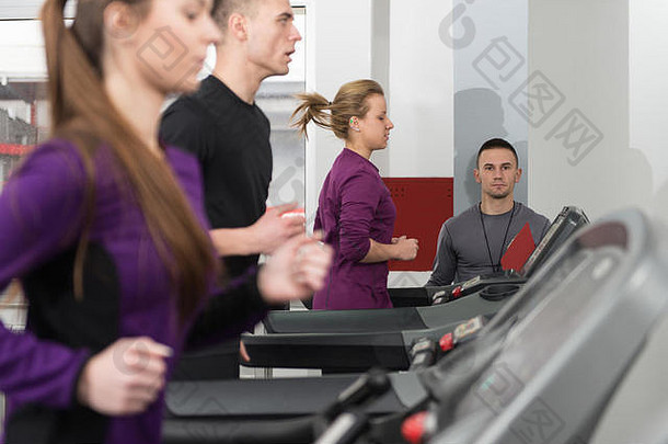 集团年轻的人运行跑步机健身房健身俱乐部个人教练测量时间秒表