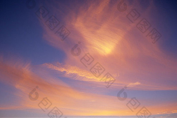 薄纤细的卷云云吹似鸟的形状发光的粉红色的橙色设置太阳