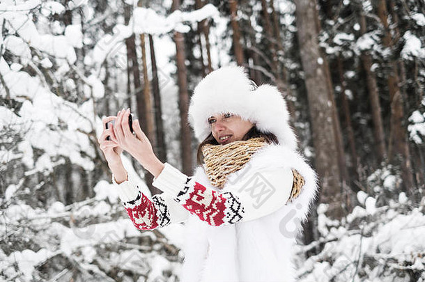 美丽的女人采取自拍在户外自然雪树背景