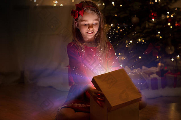 微笑女孩开放圣诞节礼物晚上