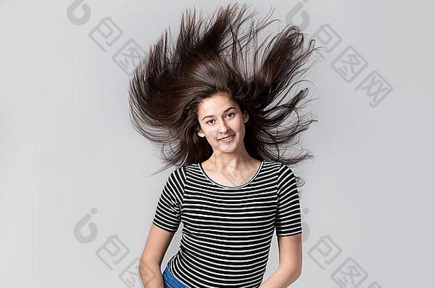 肖像美丽的年轻的快乐适合现代女人飞行头发工作室图像灰色的背景