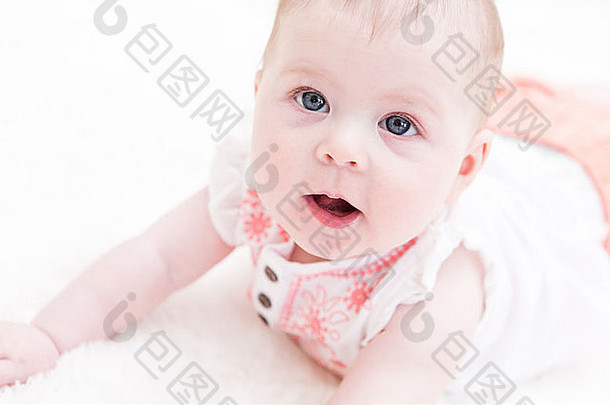 可爱的婴儿女孩玩白色毯子