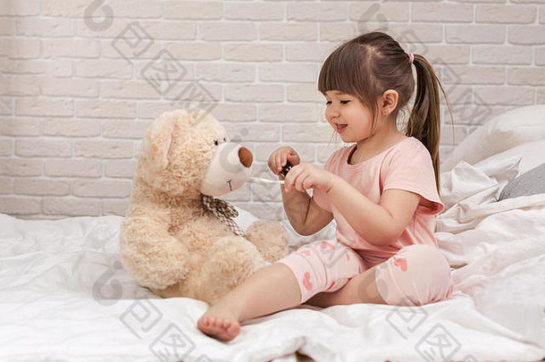可爱的孩子女孩玩医生泰迪熊首页
